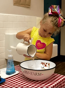 A child using the pink tower to develop spatial awareness and motor skills.