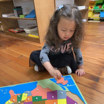 Children practicing fine motor skills with Montessori bead threading exercises.